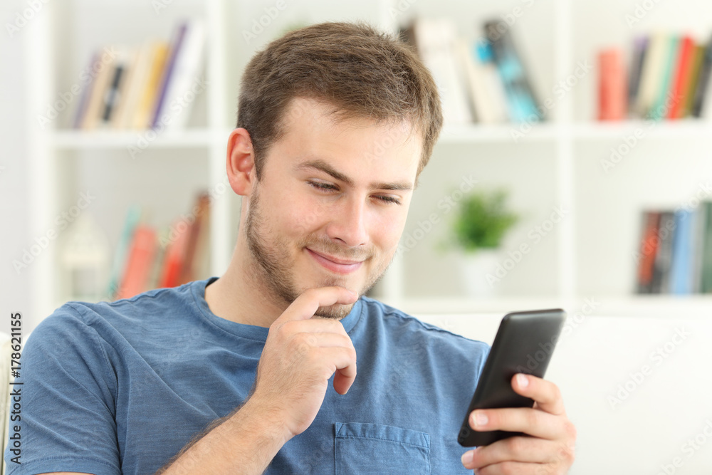 Man dating on line with a smart phone at home Man dating on line with a smart phone at home