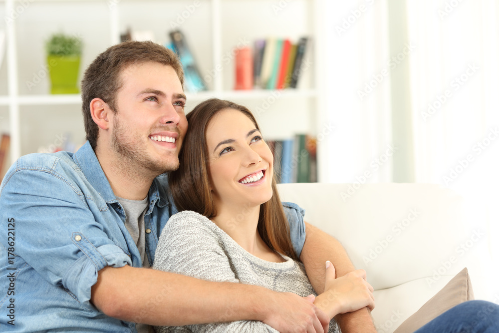 Happy couple dreaming looking above at home