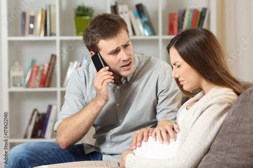 Pregnant woman suffering and husband calling to doctor