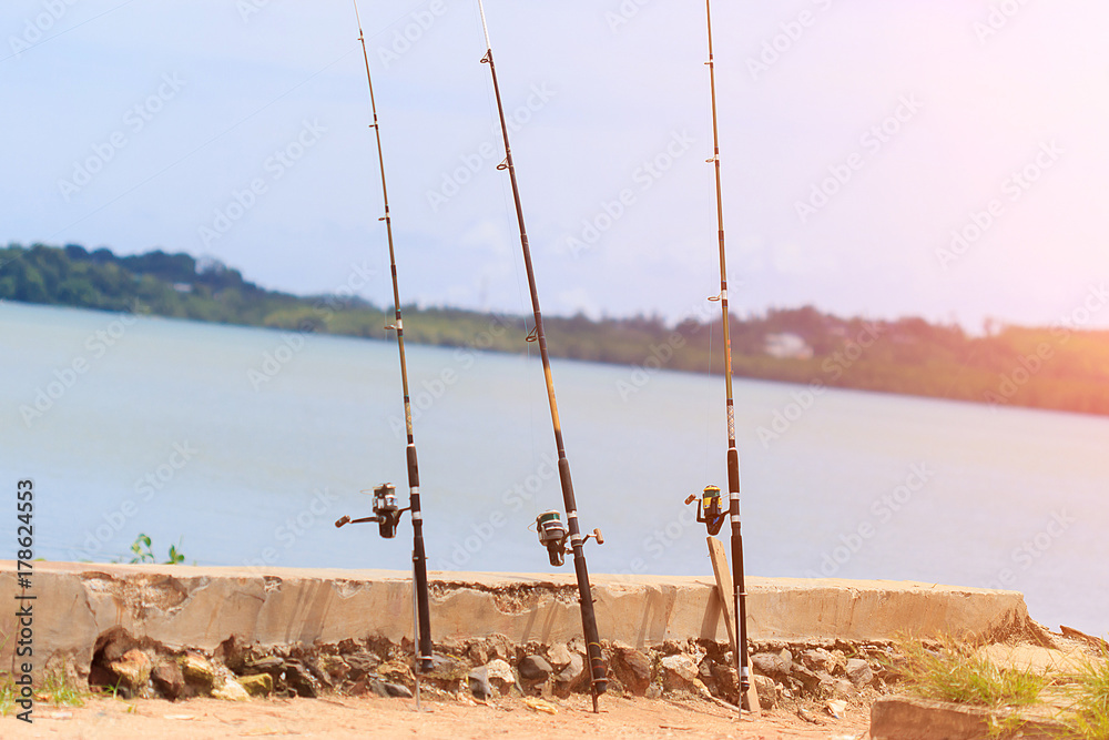 Three fishing poles mounted on the holder and set up at the beach Thailand