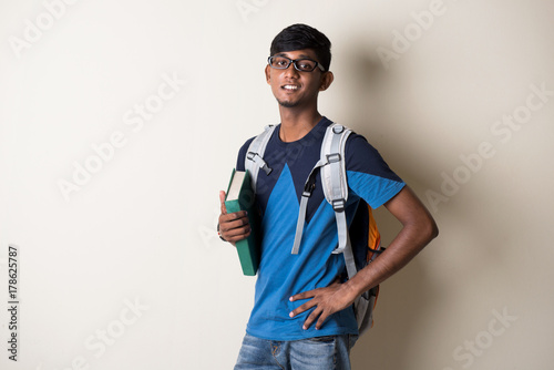 indian teenage male holding a book