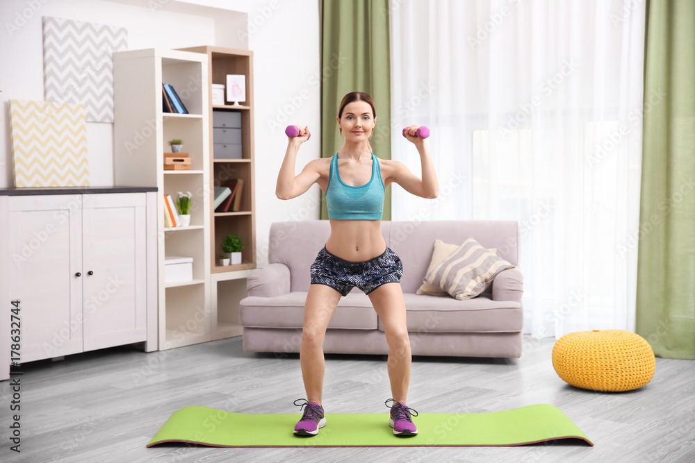 Fototapeta premium Young beautiful woman training at home