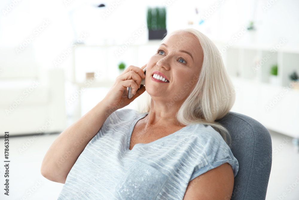 Senior woman speaking on cell phone at home Senior woman speaking on cell phone at home