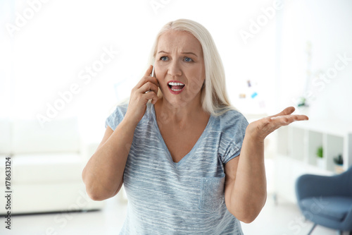 Senior woman speaking on ce...
