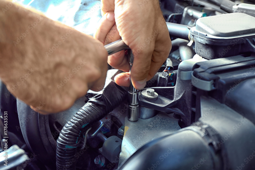 Obraz premium Car mechanic providing car service, closeup