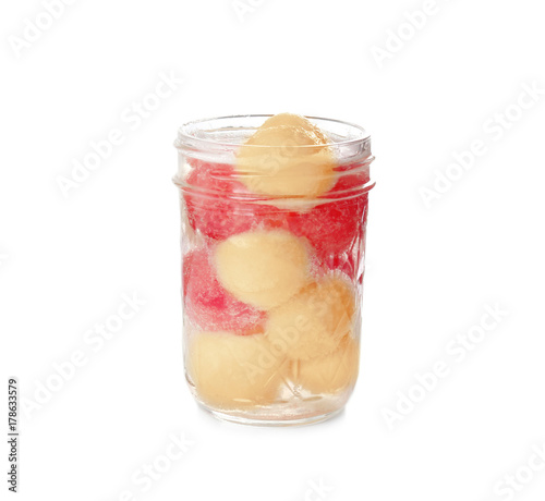 Glass jar with melon balls on white background