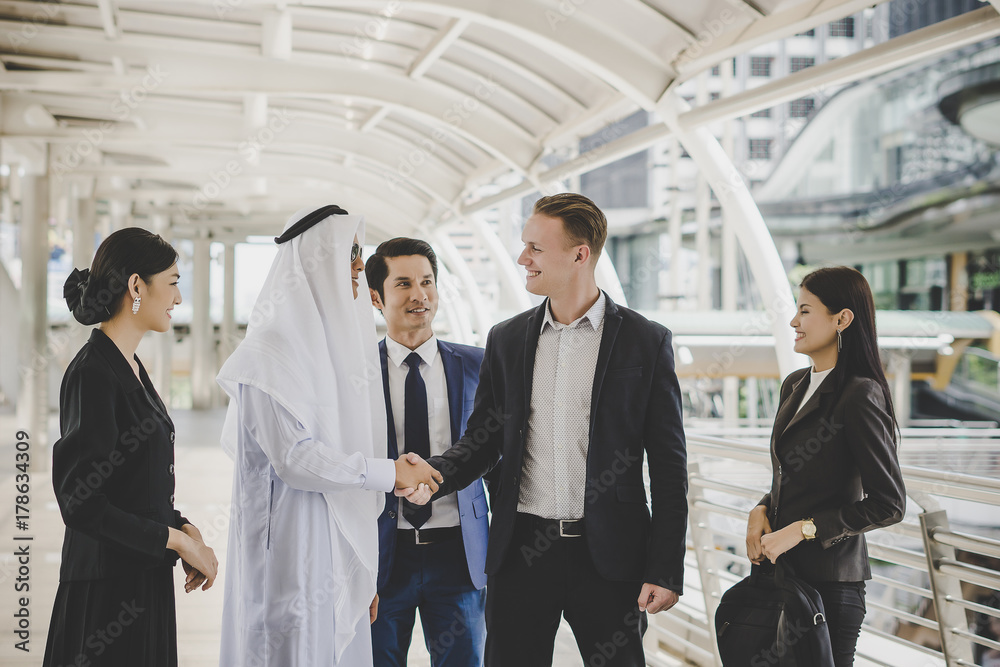 Portrait of business partners greeting one another by handshaking on the way to office. Portrait of business partners greeting one another by handshaking on the way to office.