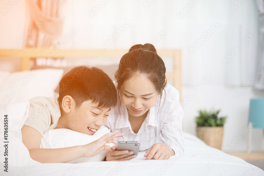 Sister and brother looking into the phone on bed. Sister and brother looking into the phone on bed.