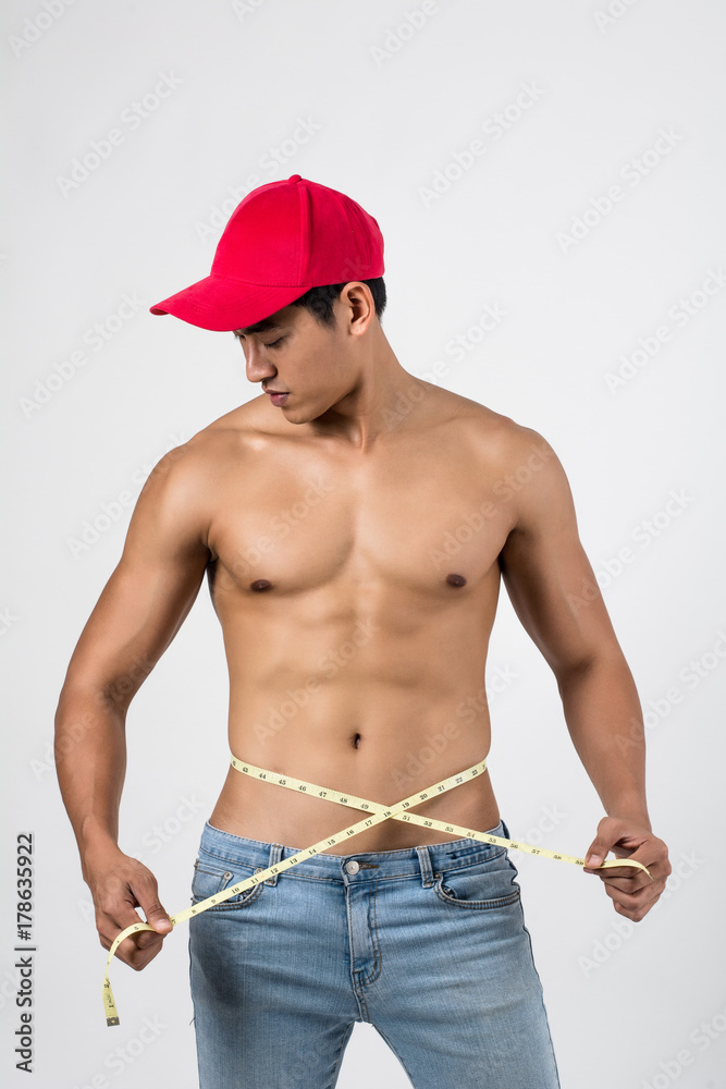 Young handsome fit man posing his muscles isolated on white background with copyspace.