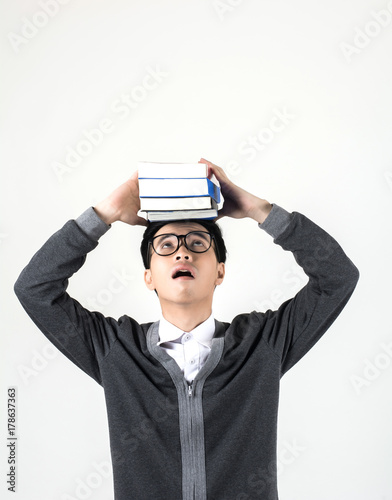 Young nerd man wearing glasses holding a book stack while standing isolated on white background.