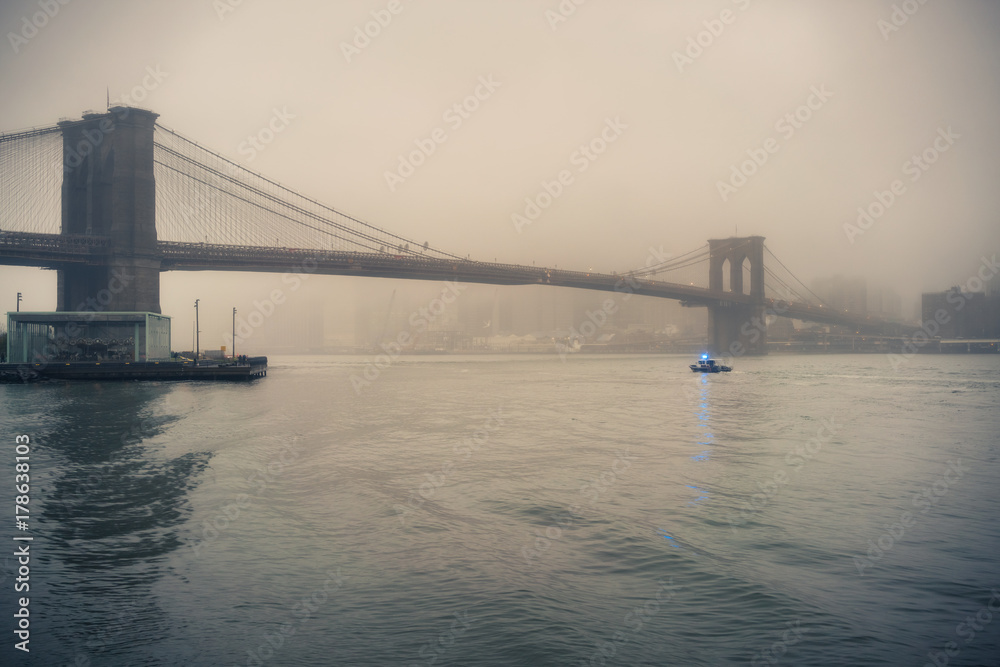 Brooklyn bridge at foggy rainy evening, New York City