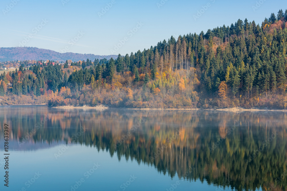 Autumn foliage reflect in calm lake