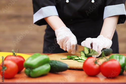 The cook cuts fresh farm vegetables