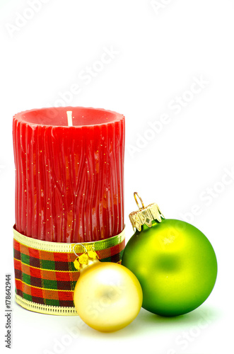 Christmas ornaments, red candle with green and golden christmas spehes isolated on white background photo