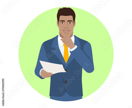 Businessman holding a paper and making hush sign