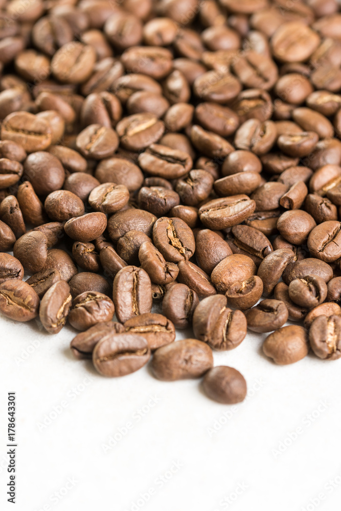 Pile of coffee beans with copy space above white marble stone Pile of coffee beans with copy space above white marble stone