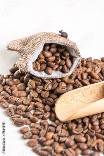 Pile of coffee beans and jute drawstring bag on the white background © zlajaphoto