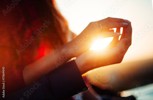 hands on sunset background, the sun in hand