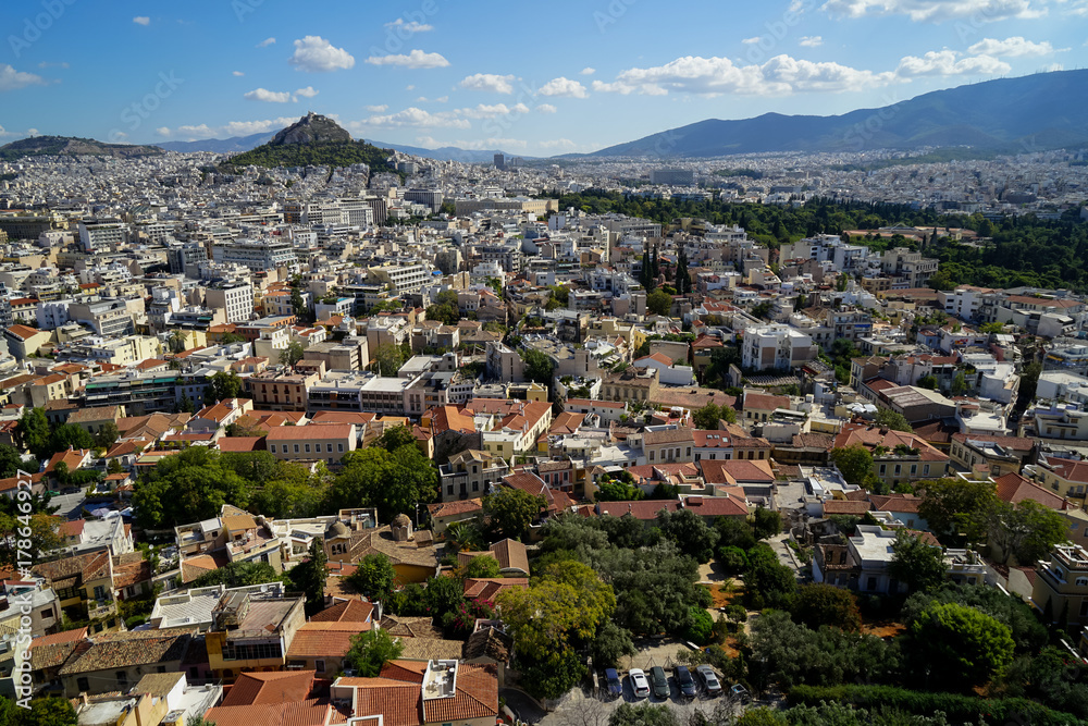 View of beautiful Athens cityscape from Acropolis seeing building architecture, Mount Lycabettus, mountain, blue sky and floating white cloud background