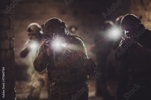 rangers during the military operation with laser sights and lanterns. photo