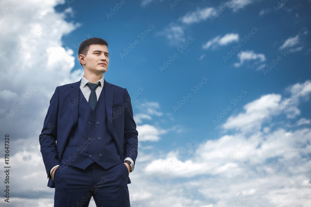 Thoughtfull groom in a blue suit smiling in the nature Thoughtfull groom in a blue suit smiling in the nature