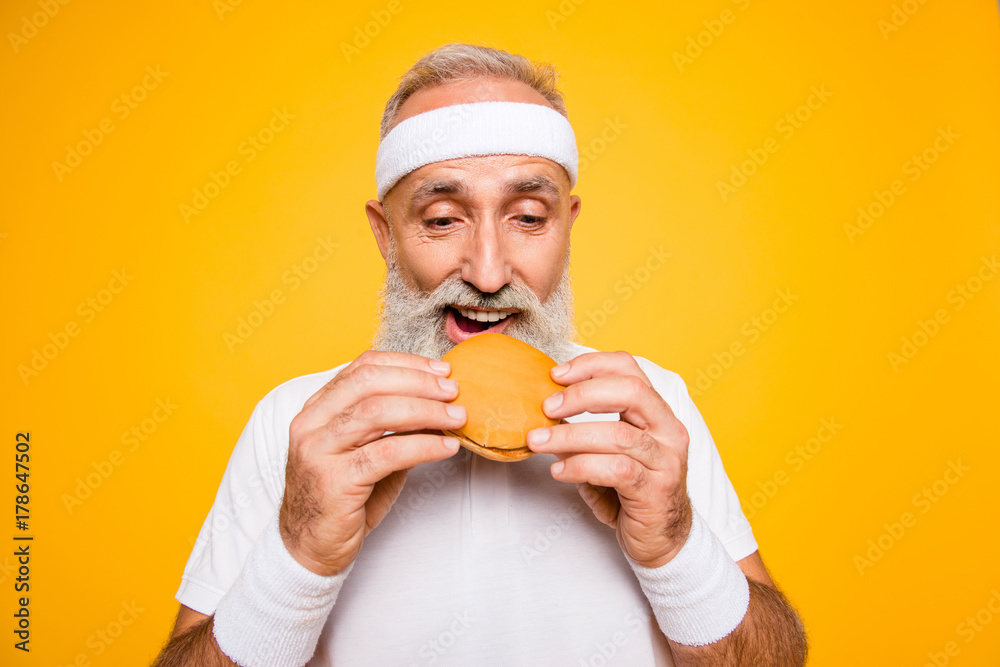 Close up of modern athlete cool grey haired pensioner grandpa hold yummy tasty delicious heavy grossy sandwich, destroys it. Weightloss, healthcare, gym, strength, regime, challenge lifestyle Close up of modern athlete cool grey haired pensioner grandpa hold yummy tasty delicious heavy grossy sandwich, destroys it. Weightloss, healthcare, gym, strength, regime, challenge lifestyle
