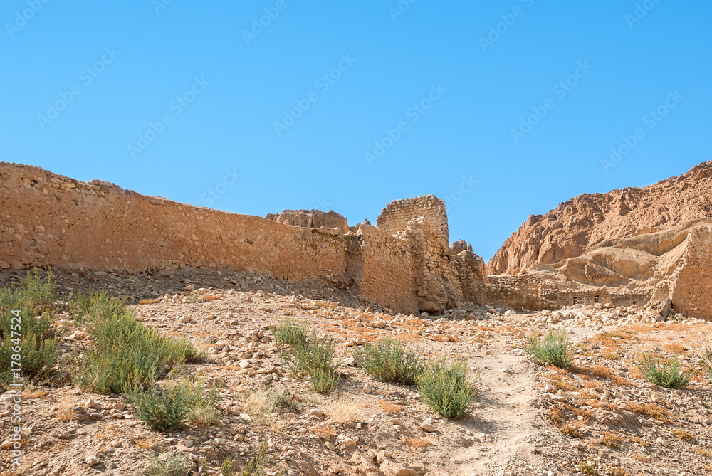 An ancient ruined stone wall in a mountain desert