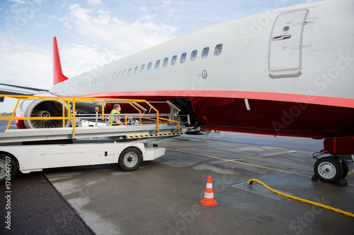 Conveyor Truck By Commercial Airplane On Wet Runway