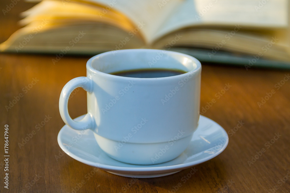 Cup of coffee and book on wooden table Cup of coffee and book on wooden table