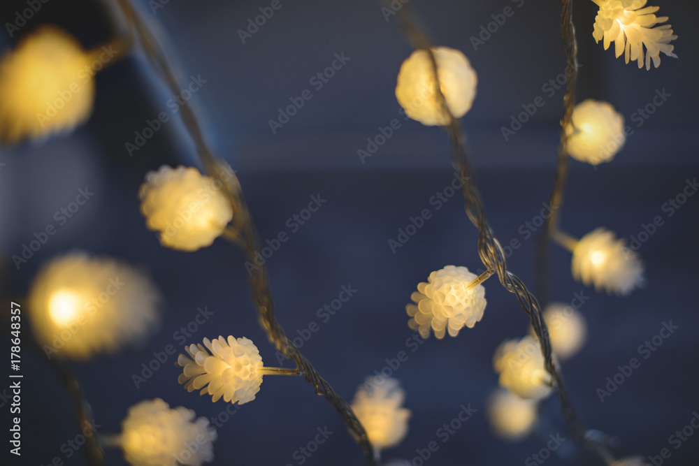 Blurred yellow christmas lights in shape of cones on dark background, low depth of focus. Blurred yellow christmas lights in shape of cones on dark background, low depth of focus.