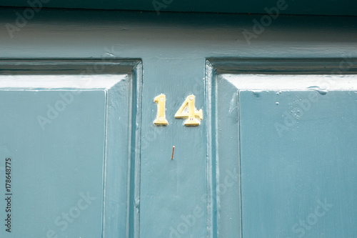 House number 14 sign on blue painted door