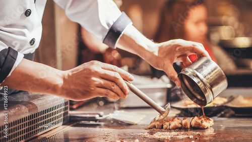 Hand of man take cooking of meat with vegetable grill, Chef cooking wagyu beef in Japanese teppanyaki restaurant