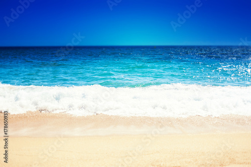 Sea Beach and Soft wave of blue ocean. Summer day and sandy beach background.