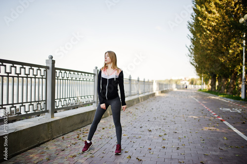 Young girl has the training and doing exercise outdoors. Sport, fitness, street workout concept.