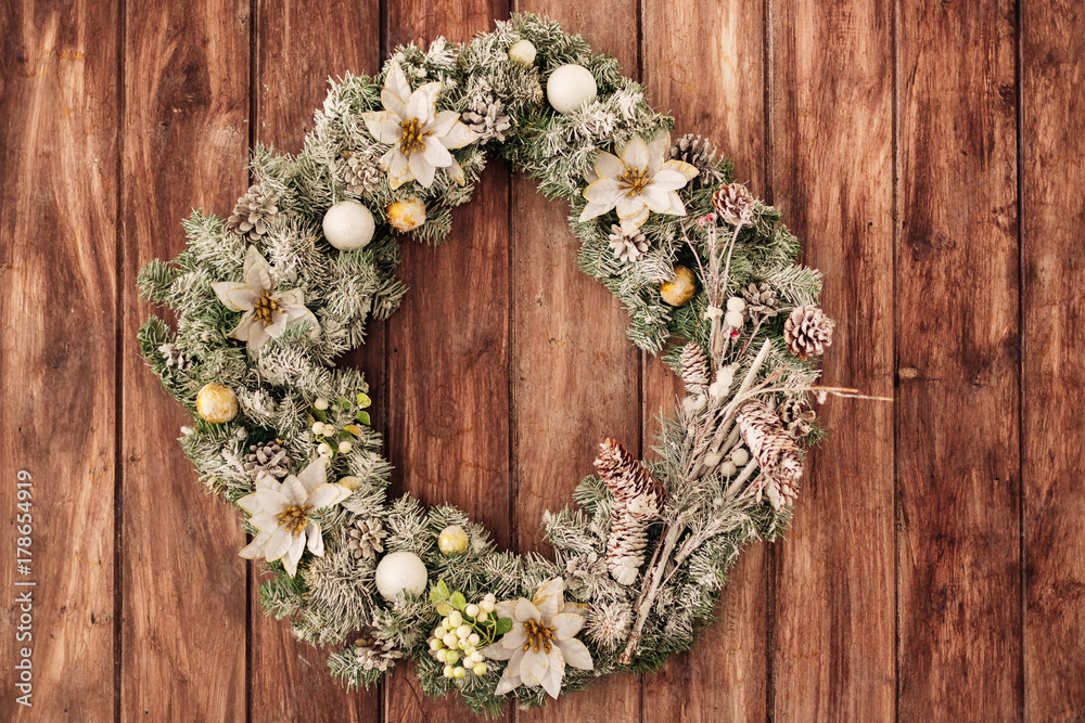 Christmas wreath with natural decorations hanging on a rustic wo Christmas wreath with natural decorations hanging on a rustic wo