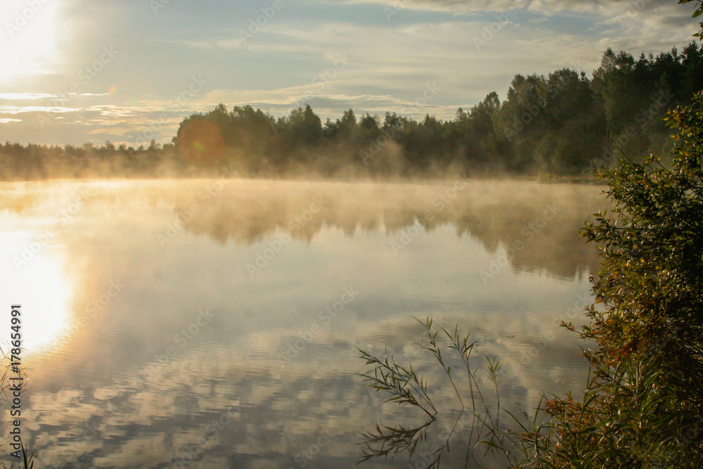 Sunrise over a misty Estonian Lake