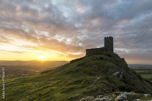 Brentor church at sunrise with beautiful sky and golden hues, Brentor, Devon, UK