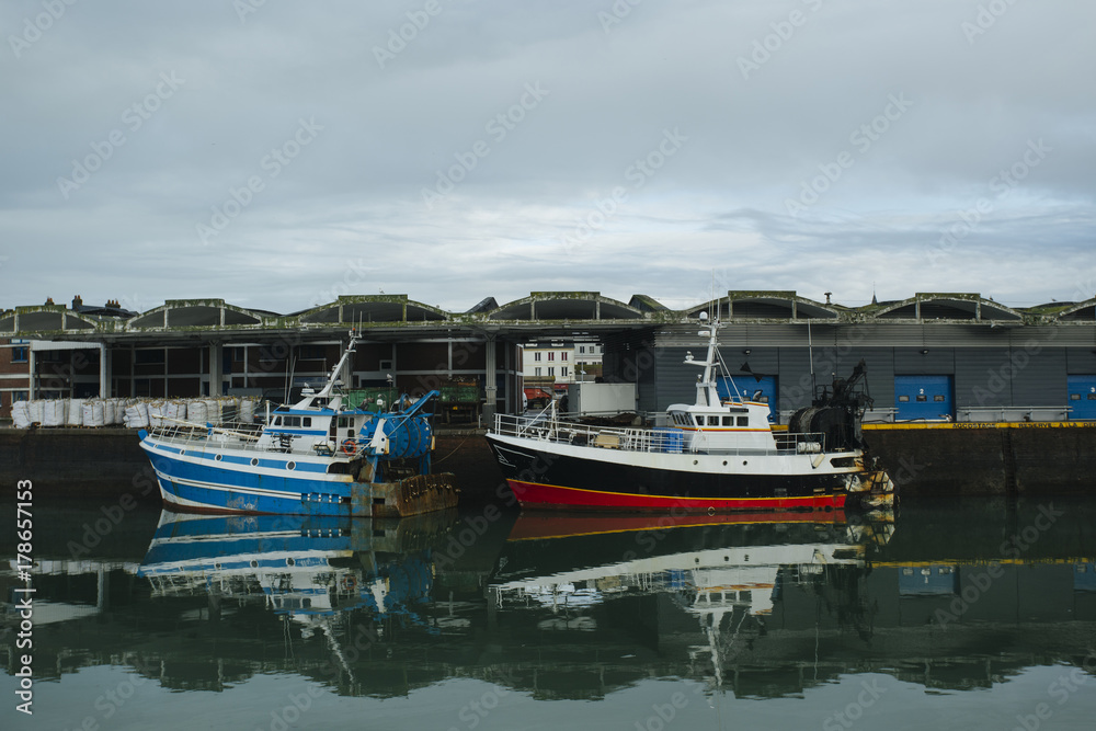 Fototapeta premium Fishing boats in a harbor. Trawler after fishing. Fishing industry, fishery. Commercial ship for seafoods in Dieppe, Normandy