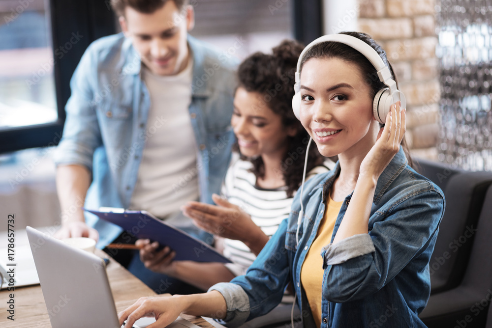 Content girl wearing headphones and working on the laptop Content girl wearing headphones and working on the laptop