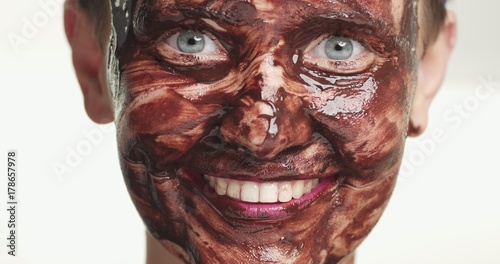woman portrait with a chocolate facial mask on a white background