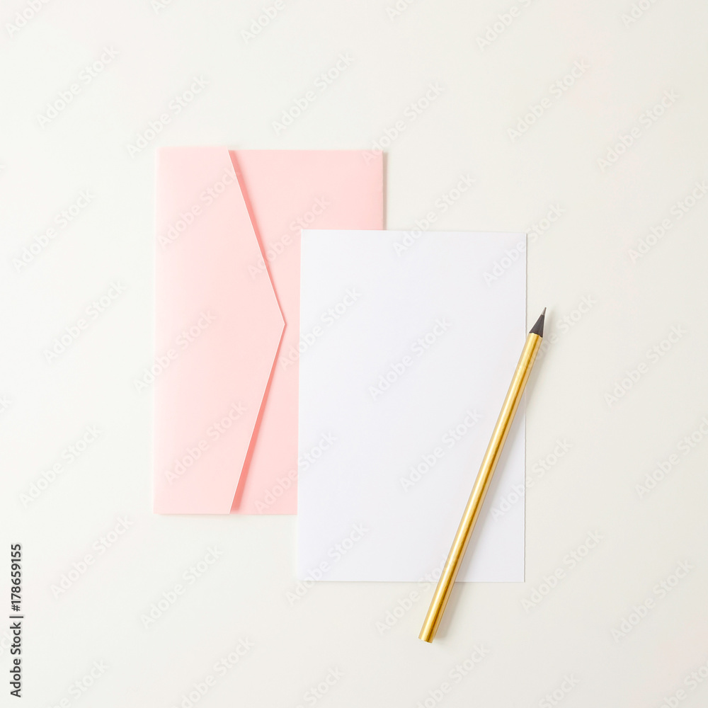 Pink envelope, blank paper, golden pencil on white background