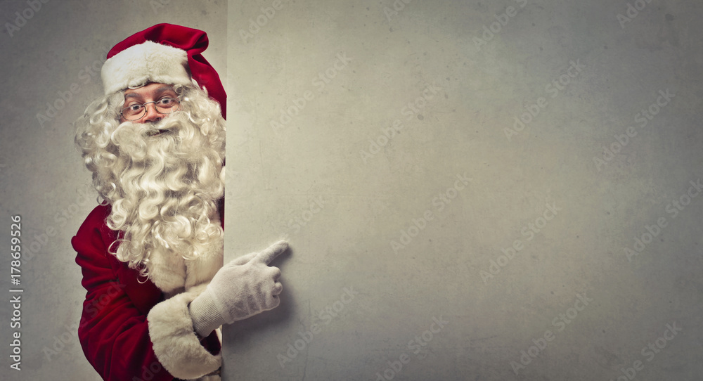 Santa Claus pointing at a blank space - obrazy, fototapety, plakaty 