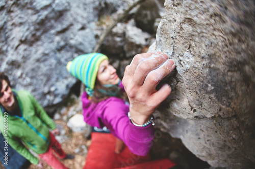 female rock climber climbs on a rocky wall. winter bouldering session