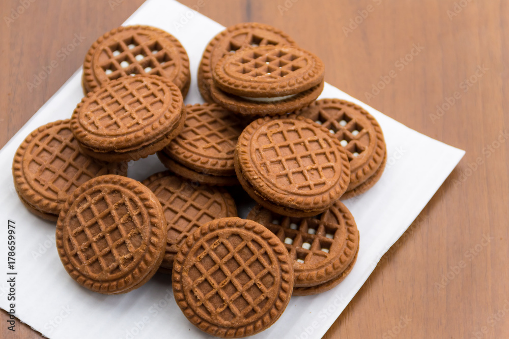 Chocolate cookies with cream filling on wooden table Chocolate cookies with cream filling on wooden table
