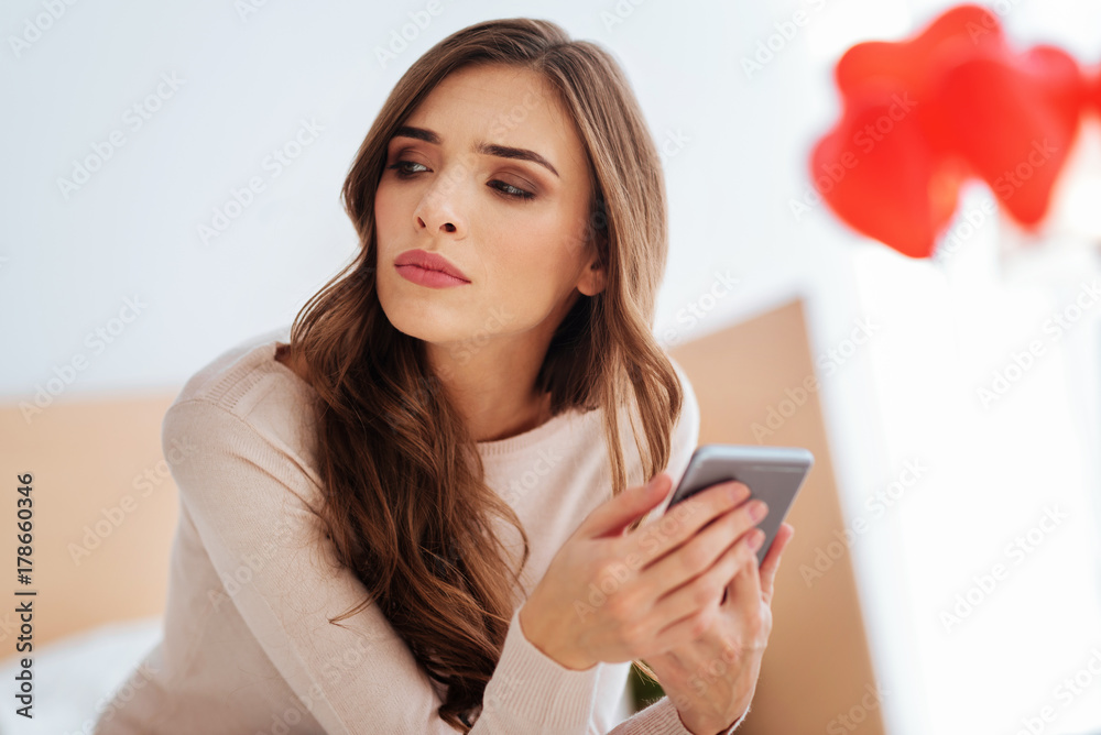 Serious lady thinking about something while using phone Serious lady thinking about something while using phone