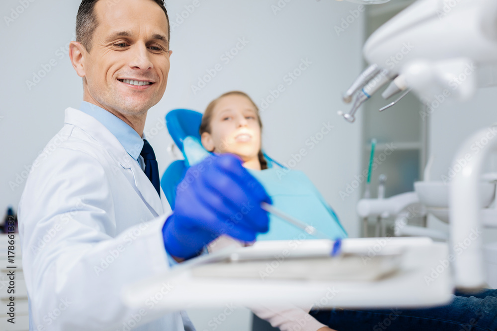 Obraz premium Happy nice dentist taking a mirror