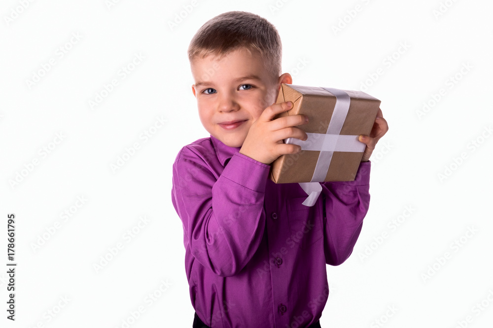 Smiling funny child holds a gift in his hands.