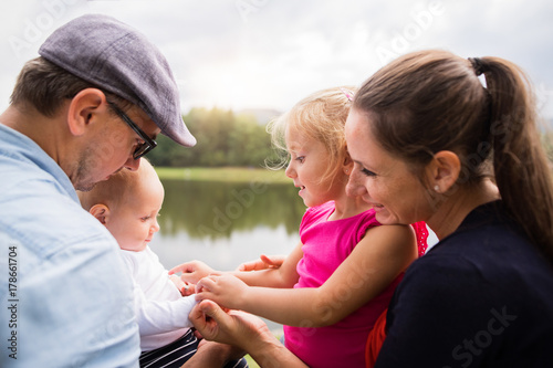 Happy family in nature by the lake in summer.