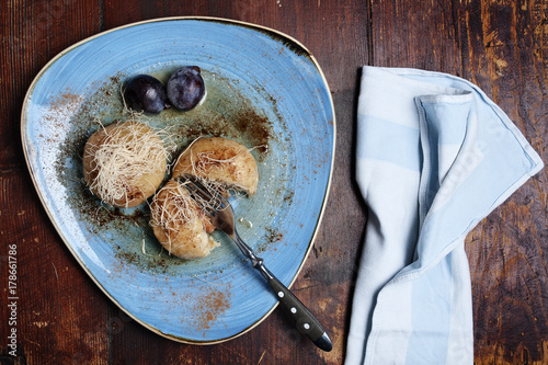 Plum gnocchi with cheese on the azure dish.