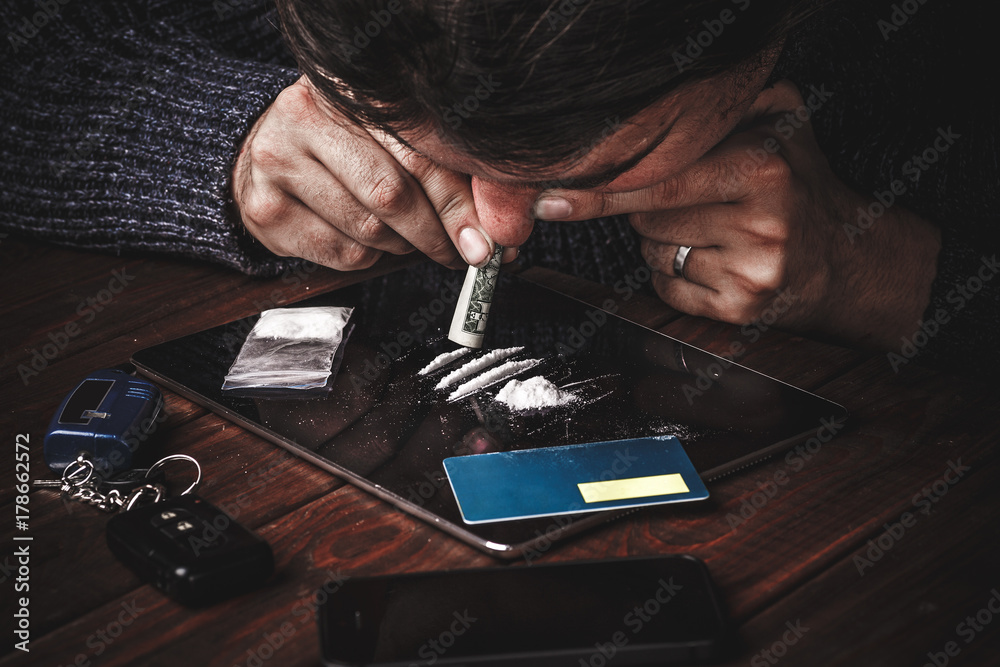 Drug abuse, man taking drugs, snorting lines of cocaine powder foto de